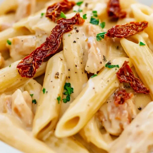 Close-up of creamy Marry Me Chicken Pasta with penne, sun-dried tomatoes, and parsley – a popular dish in the USA.