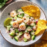 Vibrant shrimp ceviche with cucumber, red onion, cilantro, and lime, served with crispy tortilla chips.