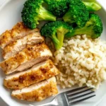 Sliced air fryer chicken breast served with steamed broccoli and fluffy rice in a bowl