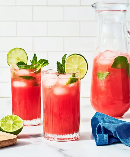 Refreshing watermelon juice served in glasses with ice, mint, and lime garnish.