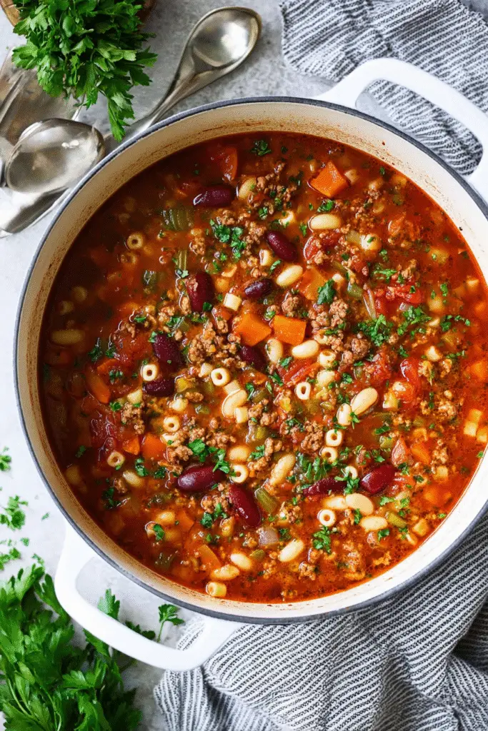 Hearty pasta fagioli soup filled with beans, ground beef, carrots, celery, and pasta in a savory tomato broth.